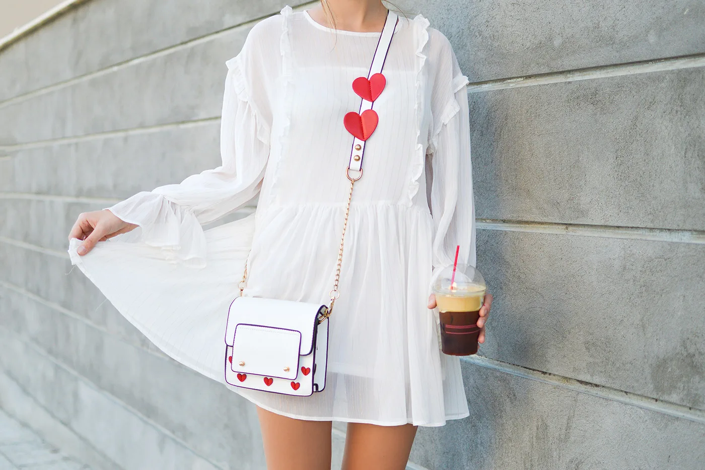 一位身着白色连衣裙的女士手持咖啡，进行拍照 - 米兰体育app